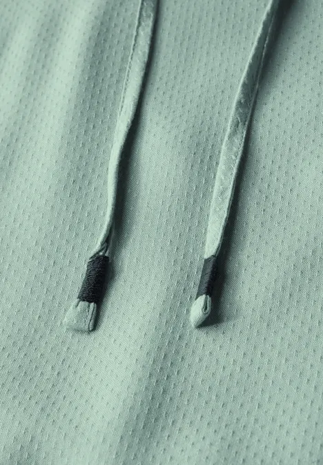 Nahaufnahme von mintfarbenem Stoff mit zwei Kordeln.